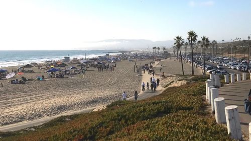 People walking on beach against sky