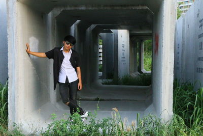 Portrait of young man standing in concrete structure
