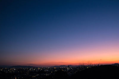 Illuminated cityscape against sky at night