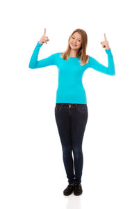 Portrait of smiling young woman standing against white background