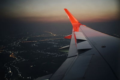 Airplane flying in sky at sunset