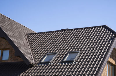 Low angle view of roof and building against clear sky