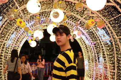 Friends standing against illuminated lights at night