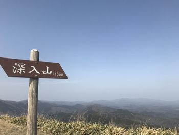 Road sign against clear sky