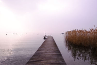 Pier over lake against clear sky