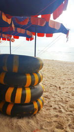 Close-up of multi colored umbrellas on beach against sky