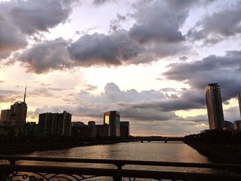 Modern buildings in city against sky during sunset