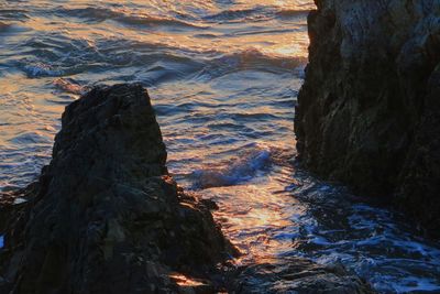 High angle view of rocks at shore during sunset