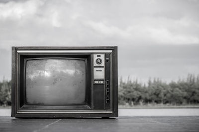 Abandoned television set against sky