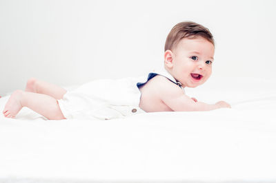 Portrait of cute baby lying down against white background