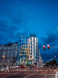 Low angle view of buildings in city against blue sky