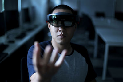 Portrait of young man gesturing while wearing virtual reality simulator