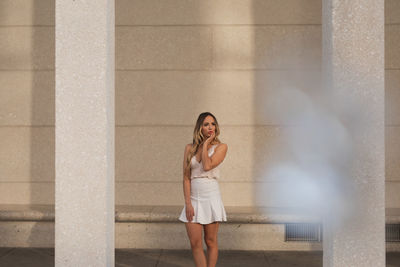 Full length of woman standing against wall