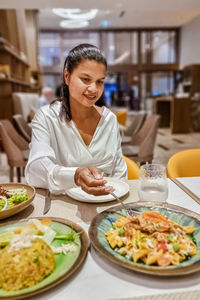 Portrait of woman having food in restaurant