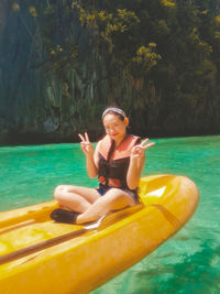 Portrait of smiling young man sitting in swimming pool
