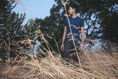 Low angle view of teenage boy standing on field