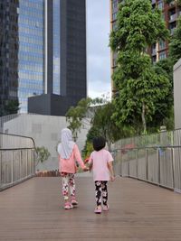 Children holding hands walking together in lalaport kuala lumpur