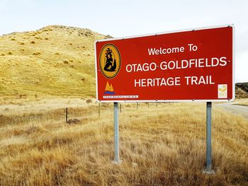 Information sign on grass against clear sky