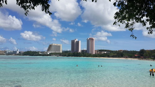 View of buildings in city against cloudy sky