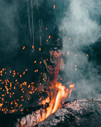 Low angle view of man with fire crackers at night