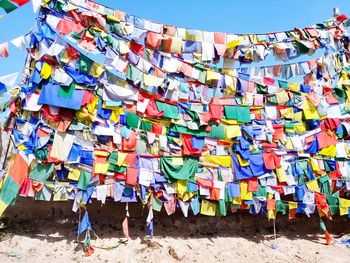 Multi colored umbrellas hanging on beach against sky