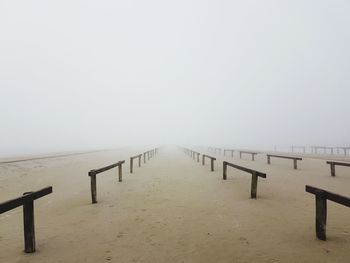 Wooden pier on sea against sky during foggy weather