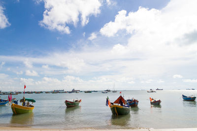 Boats moored on sea against sky