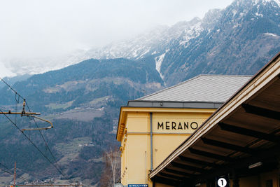 Text on snow covered mountain against sky