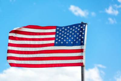 American flag waving against cloudy sky