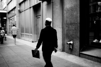 Rear view of man walking on building