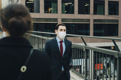 Portrait of young man standing at office building