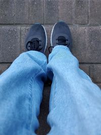 Low section of person standing against blue wall