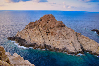 Rock formations in sea against sky