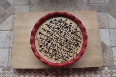 High angle view of mocha ice cream in red bowl on cutting board