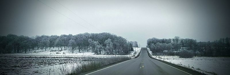 Road amidst trees against sky