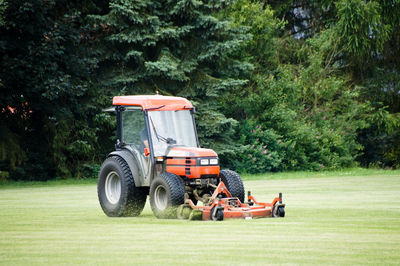 Man driving tractor on grassy field