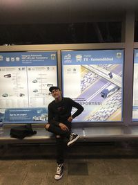 Portrait of young man standing at railroad station