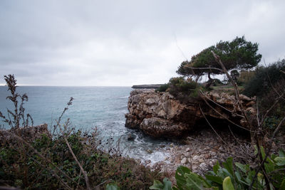 Rocks by sea against sky