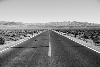 Empty road on landscape against clear sky