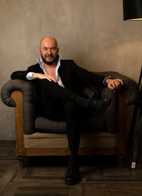 Portrait of man sitting on sofa at home