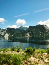 Scenic view of lake by mountains against sky