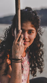 Portrait of smiling young woman against sky