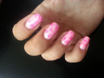 Close-up of hand holding pink flower