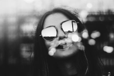 Close-up portrait of young woman wearing sunglasses