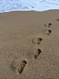 High angle view of footprints on sand at beach