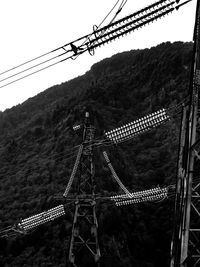 Low angle view of overhead cable car against sky