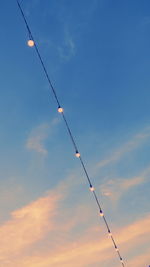 Low angle view of silhouette crane against sky