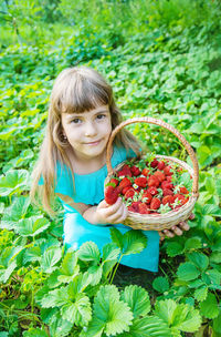 Portrait of young woman picking flowers