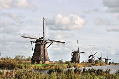 Traditional windmill on field against sky