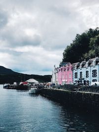 River by buildings against sky